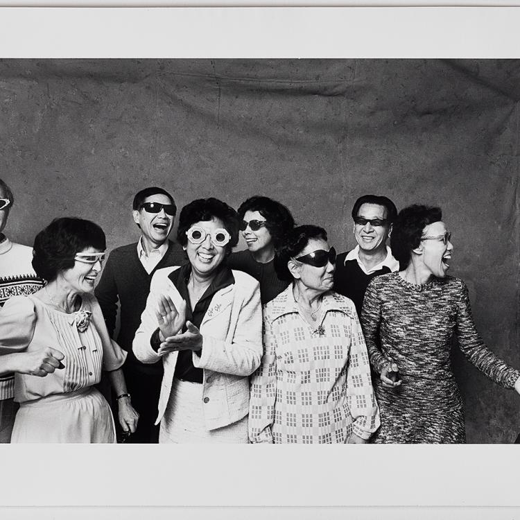 A black and white photograph of people smiling and posing for the camera