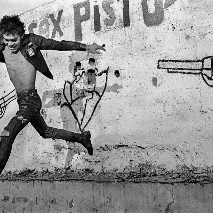An image of a man jumping behind a wall with a pistol drawn on it