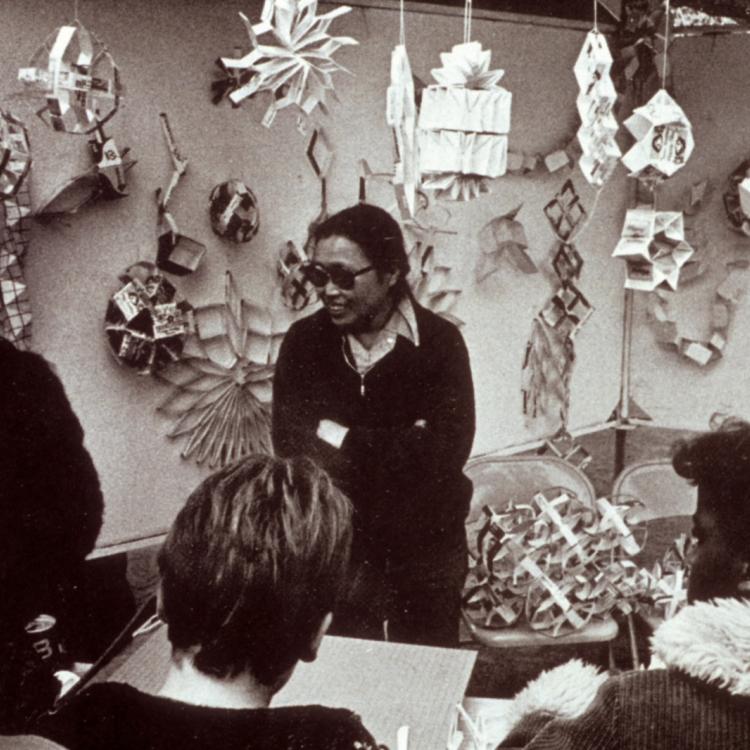 a woman artist standing infront of a crowd