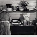 A woman in a kitchen facing away from the viewer