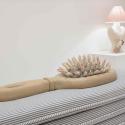 An image of a hair brush sitting on a cushion
