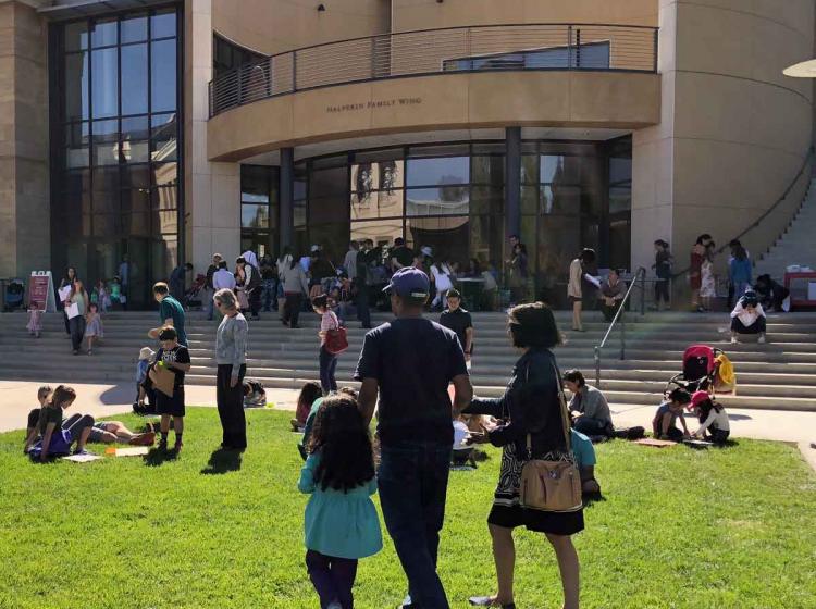 An image of a family walking on the grass outside of the Cantor with the legend Art for All Family Guides