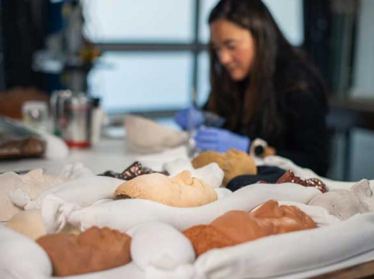 Conservator Catherine Coueignoux examines and treats each mask before public display.