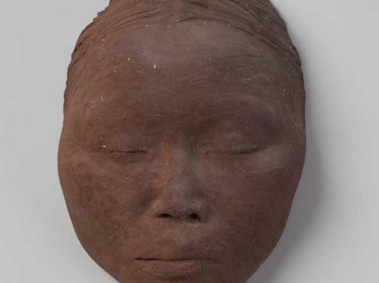 A color image of a clay portrait of the artist Ruth Asawa.