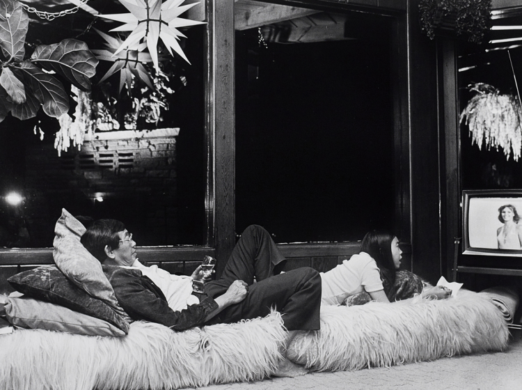 Two people laying down watching TV