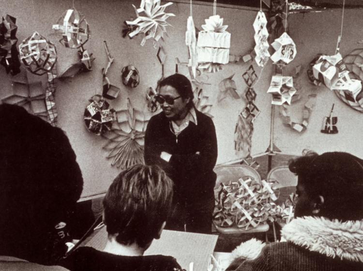 a woman artist standing infront of a crowd