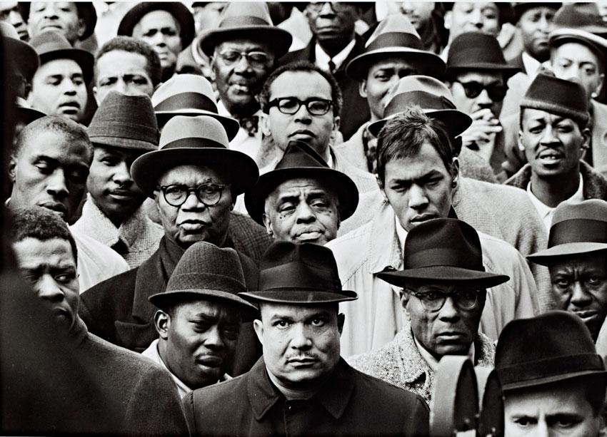 A black and white photograph depicting several black Muslim men