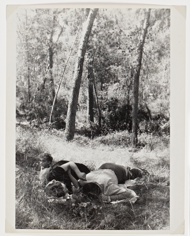 A black and white photograph of a couple with child in the woods