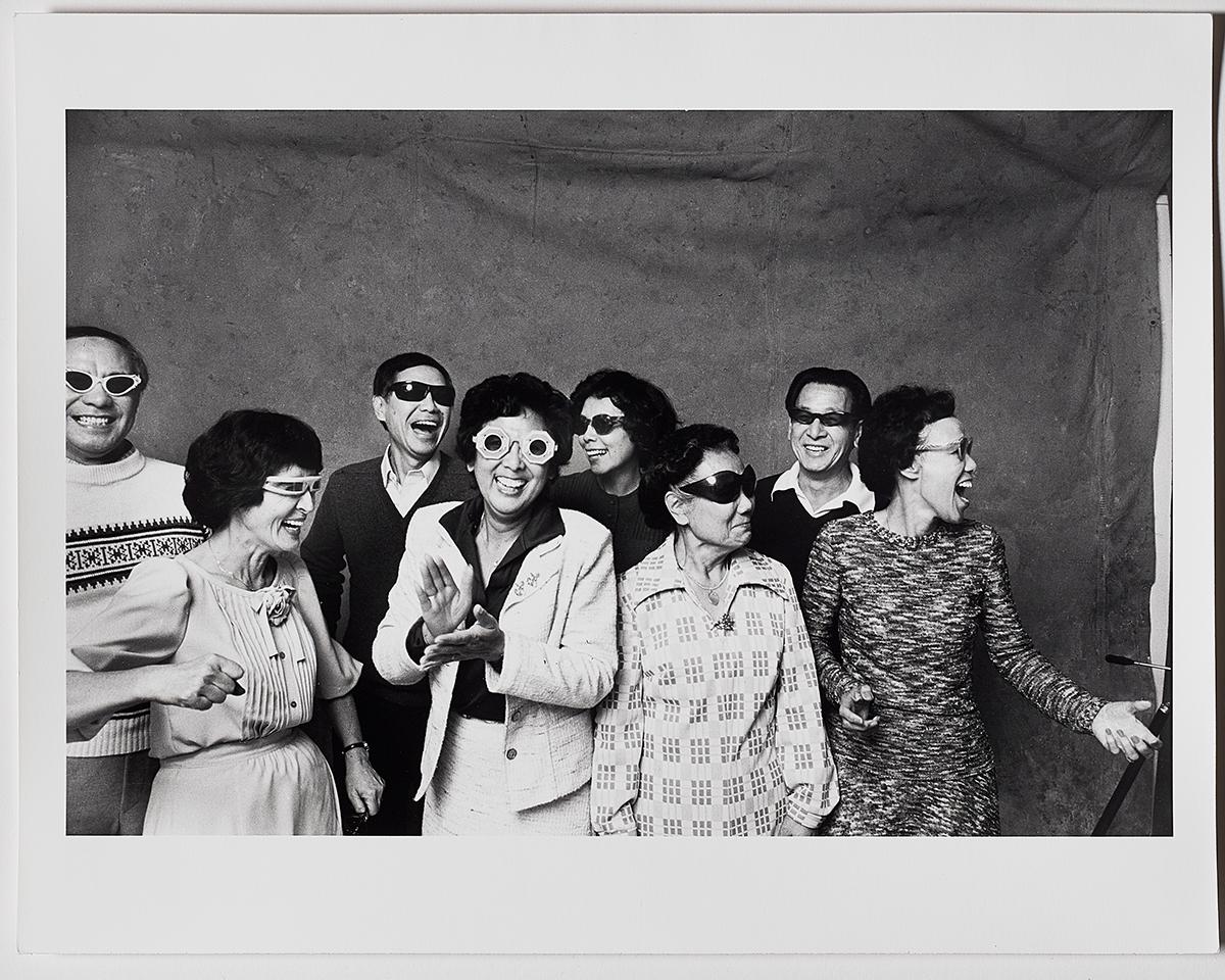 A black and white photograph of people smiling and posing for the camera