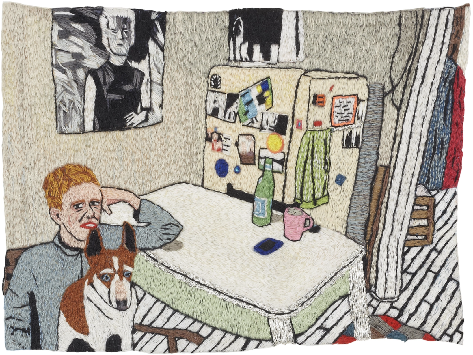 An embroidered piece depicting a person with a dog sitting in a kitchen