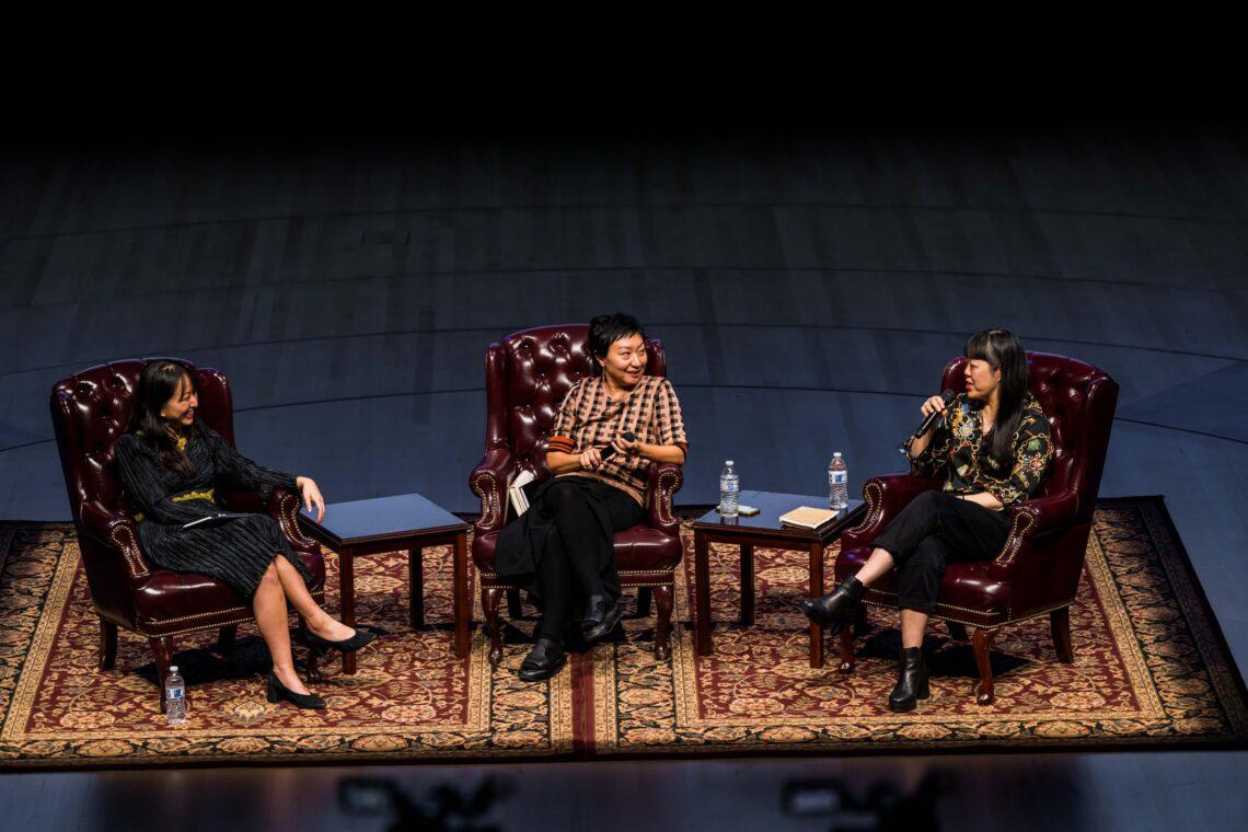 Three women on the stage during a symposium